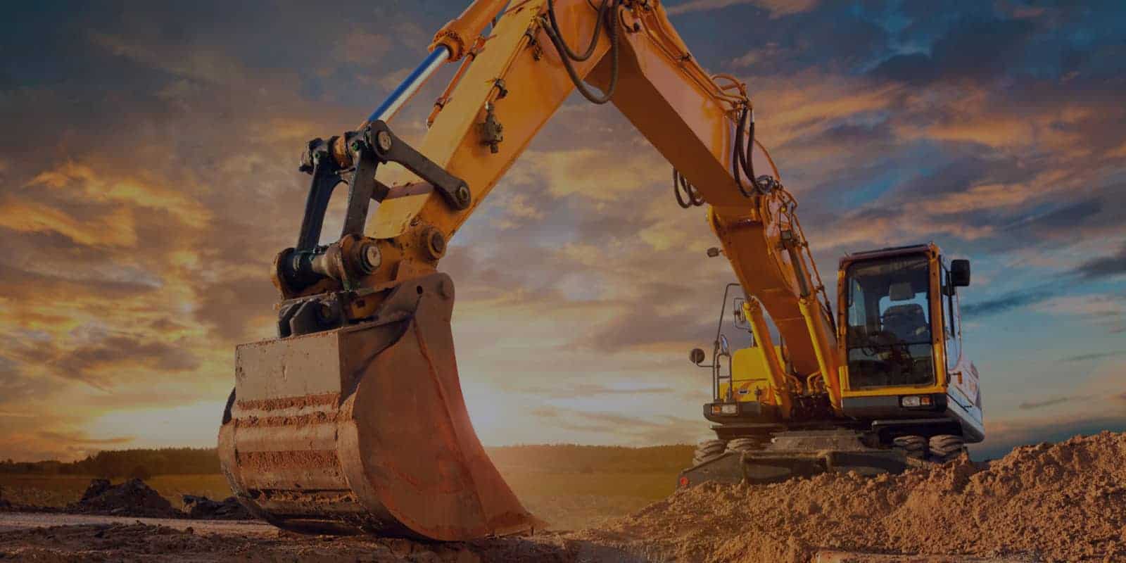 Excavator working on a CRAEMOC construction site at sunset